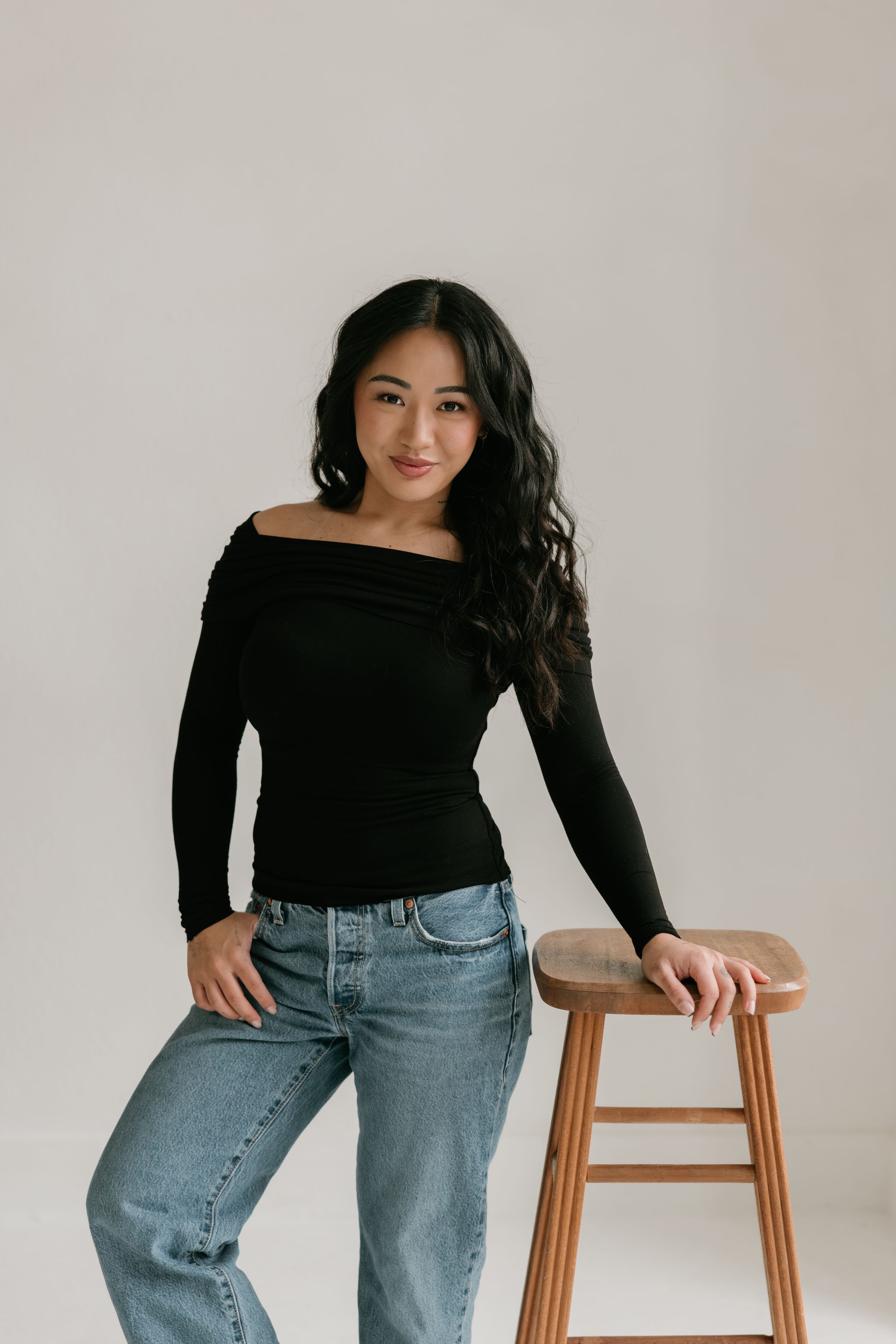 Lifestyle portraits featuring someone in a black top and jeans posing casually against a white background.