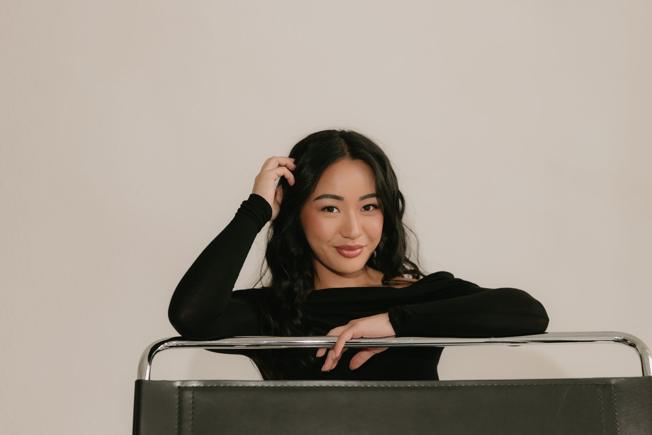 A woman in a black outfit poses gracefully in a series of connected professional studio photographs.