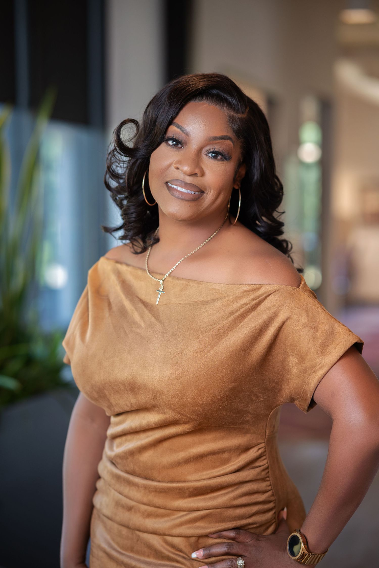 Woman in brown cowl neck top smiles confidently in professional indoor photoshoot series.