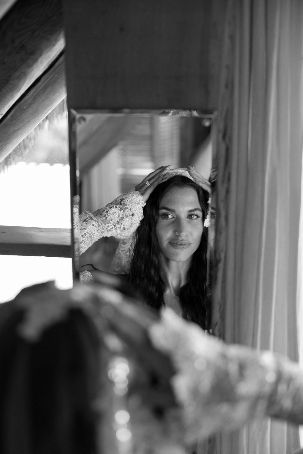 Black and white portrait of a bride with long dark hair and a delicate crown getting ready.