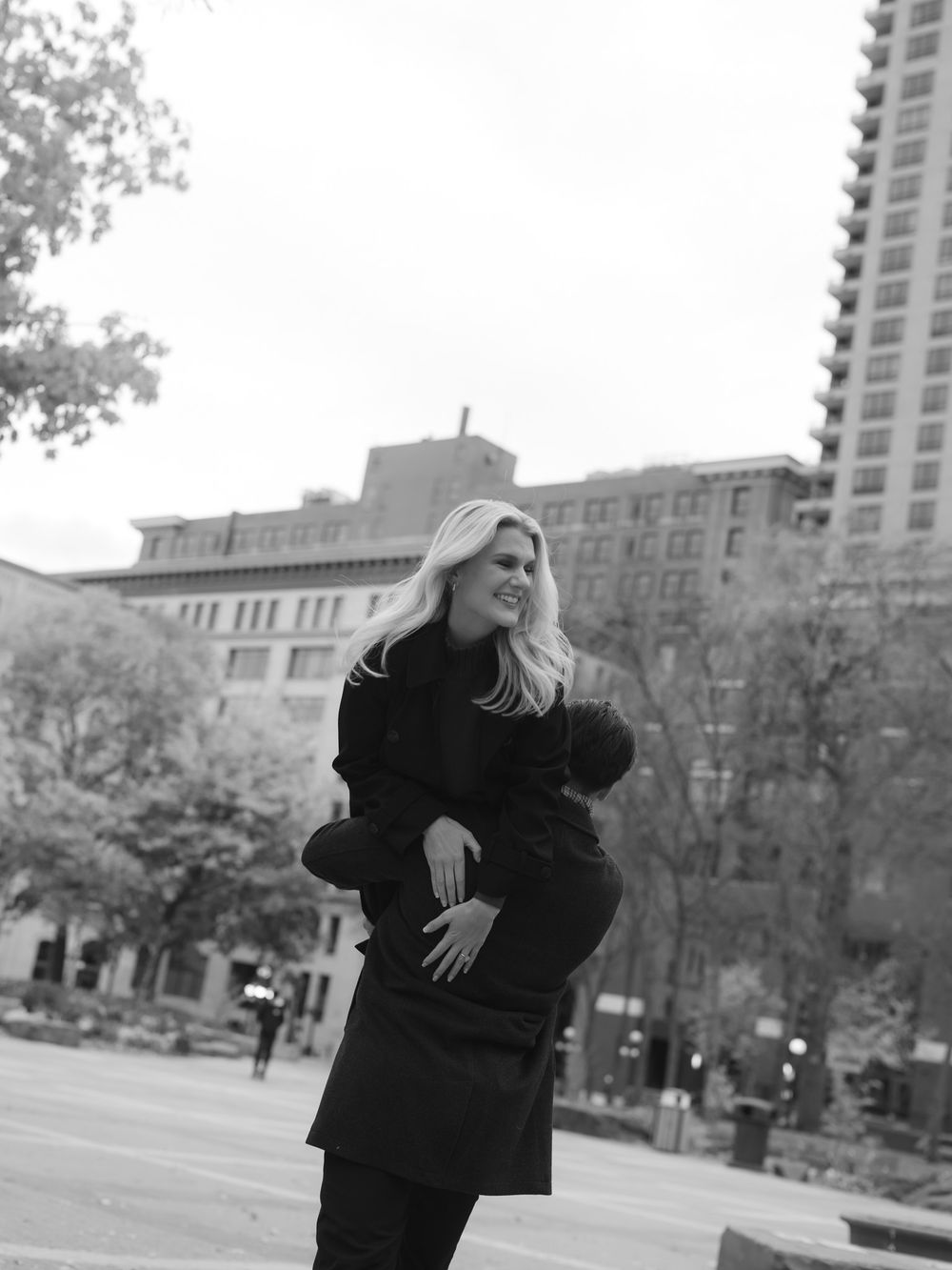 A sequence of black and white photos shows someone in a dark coat walking and spinning in an urban setting.