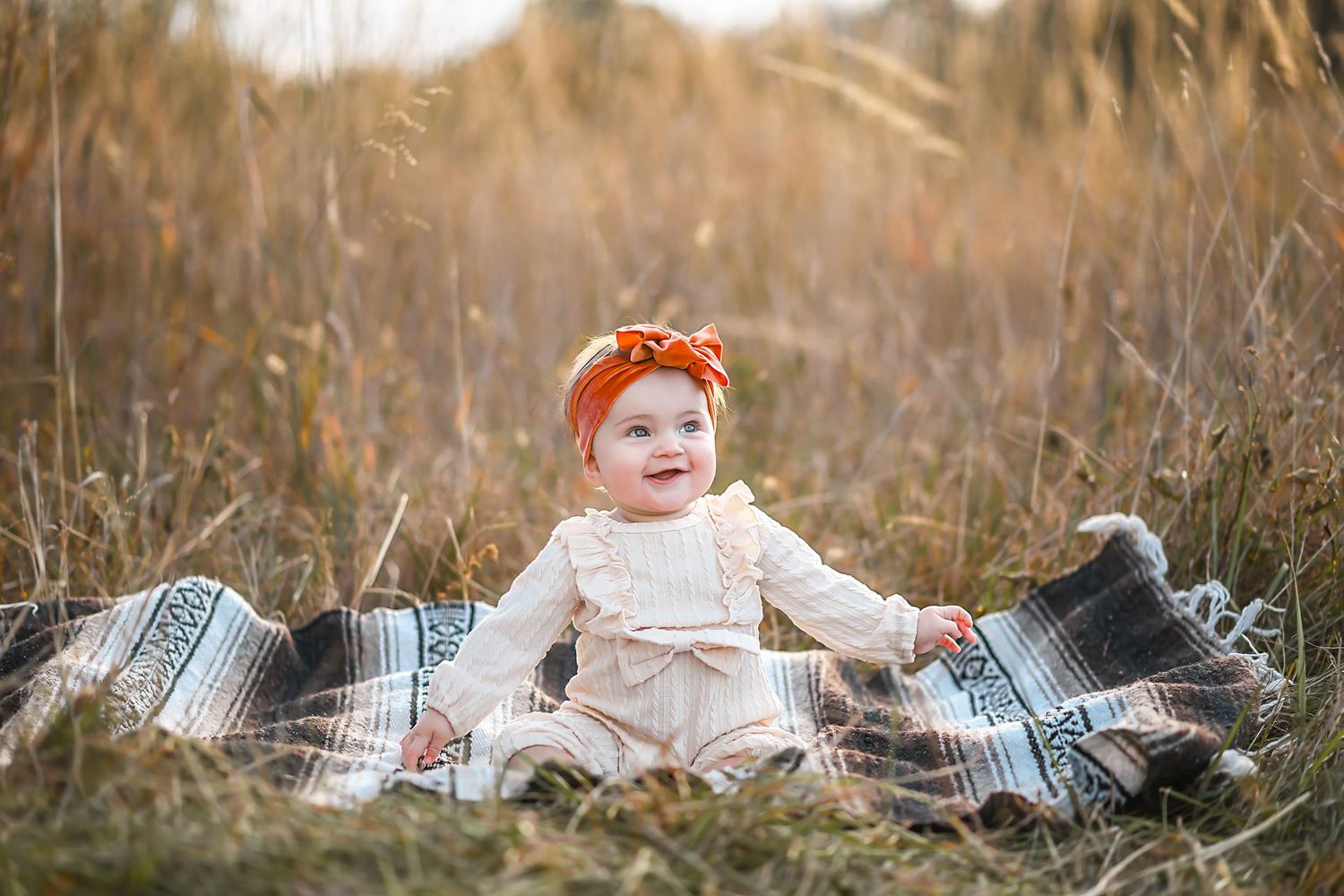 A family shares tender moments in a golden sunlit field during sunset, creating heartwarming autumn portraits.