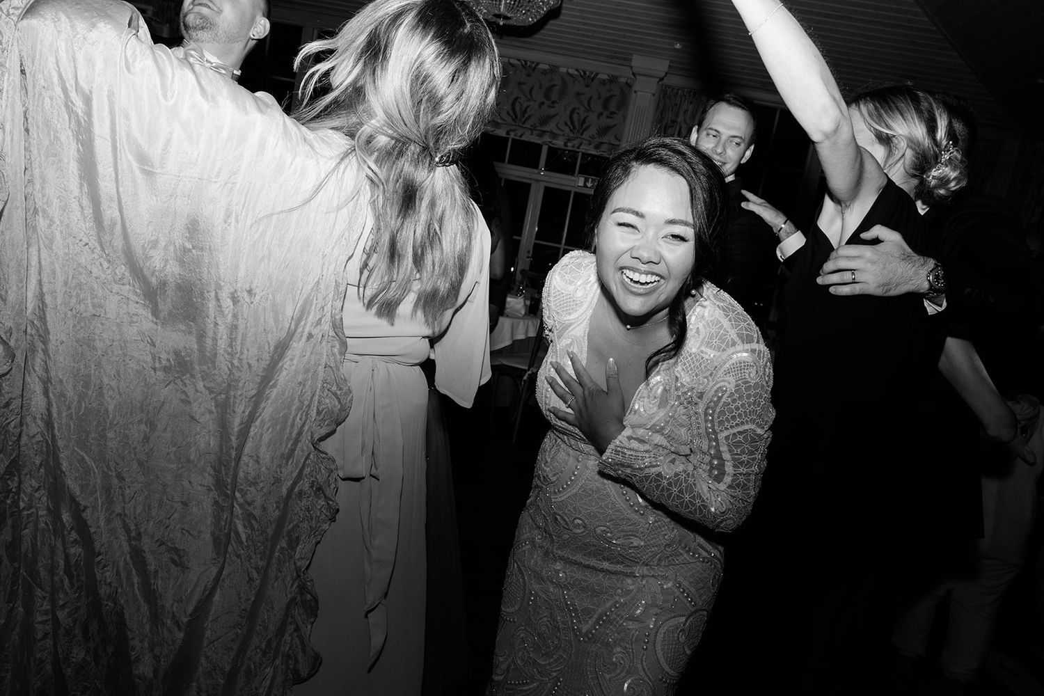 People dancing and celebrating at a lively party in black and white photography.