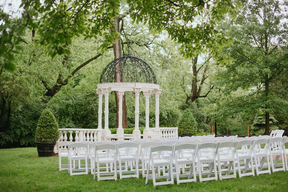 The Larimore Wedding Venue Marble Gazebo with white lawn chairs arranged for a ceremony in front.