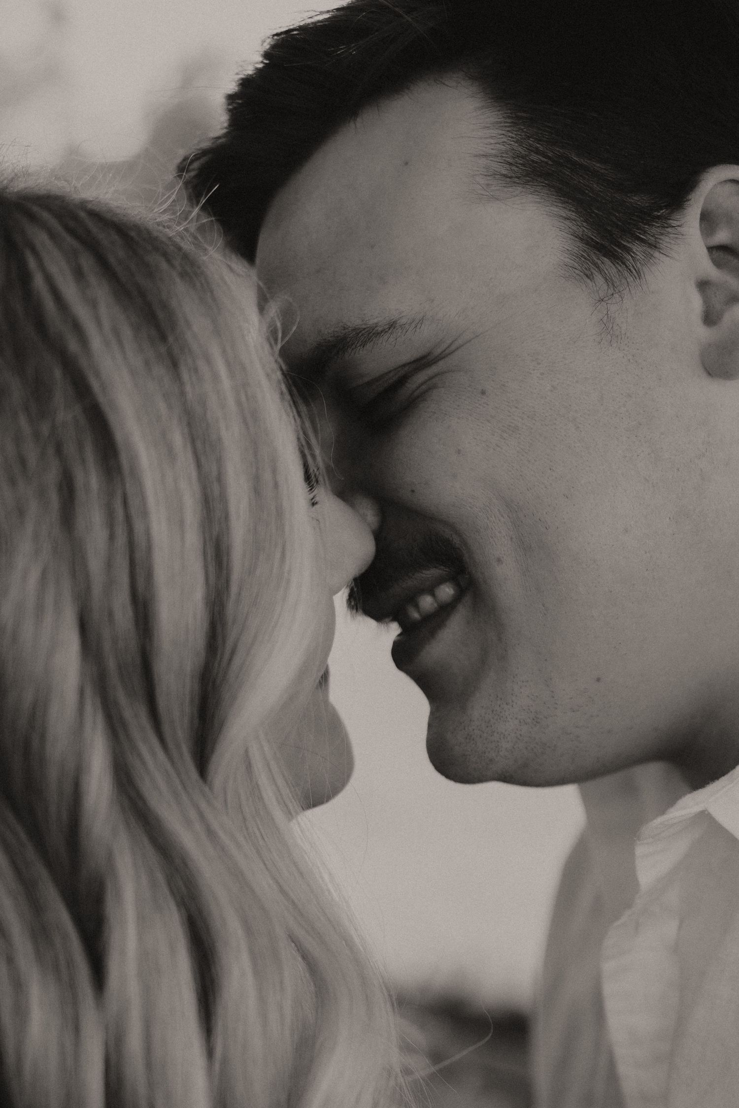 A dramatic black and white portrait of a couple in an intimate moment.