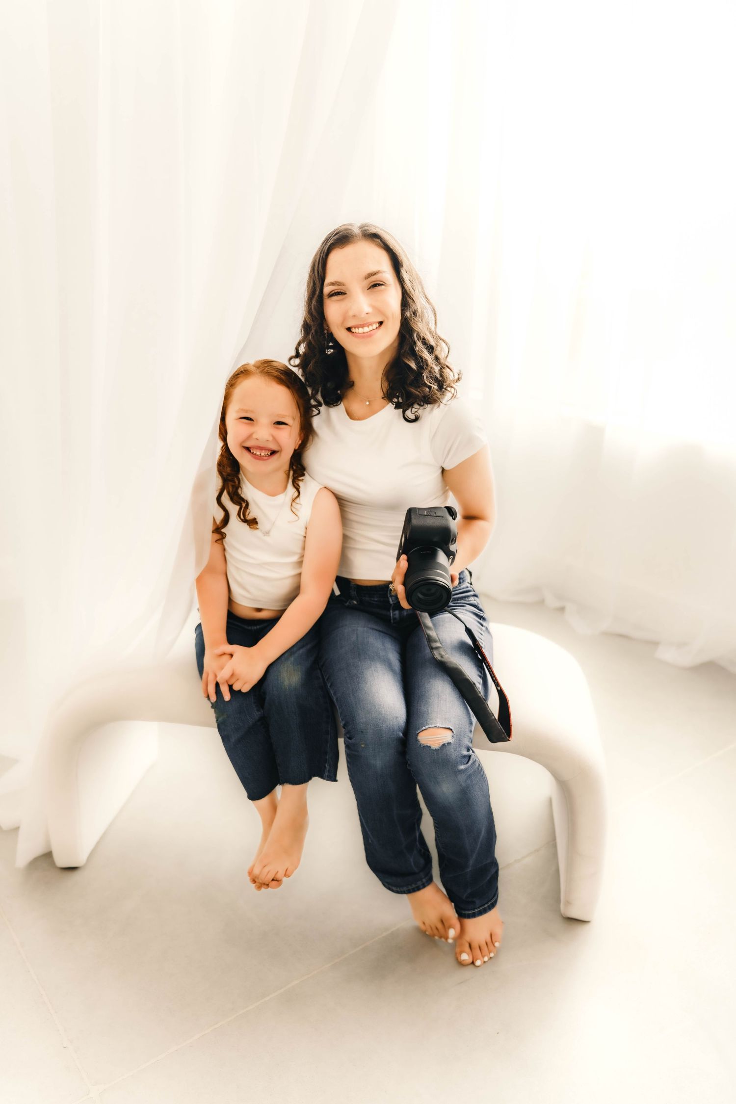 Studio portrait session with white backdrop and casual styling.