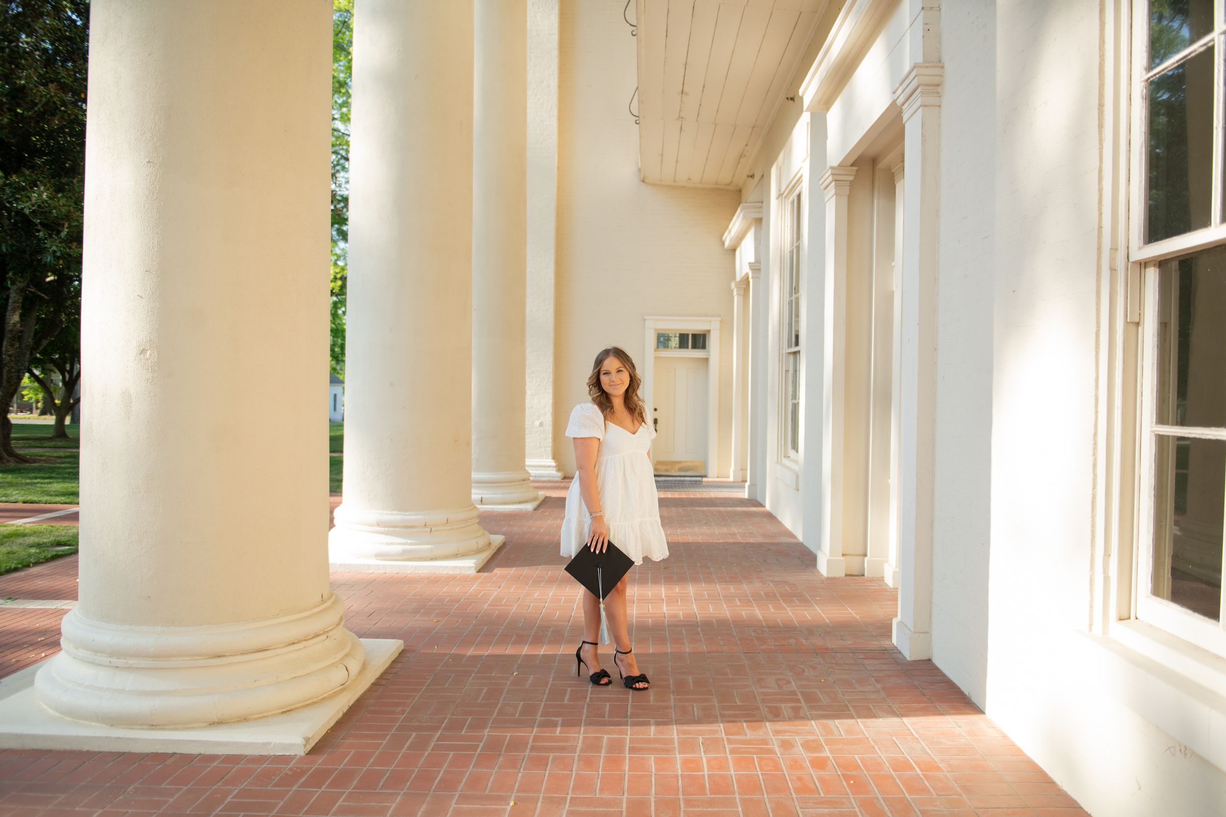 White columned walkway with natural lighting creating architectural shadows.