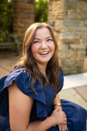 Portrait series showing joyful expressions while wearing a navy blue outfit.