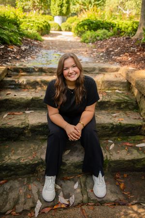 Casual outdoor portraits taken on stone steps surrounded by autumn leaves.