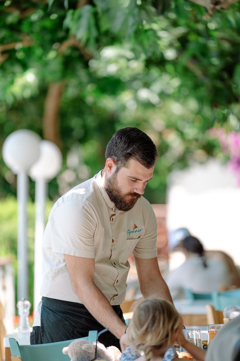Candid hospitality moment between server and guest outdoors.