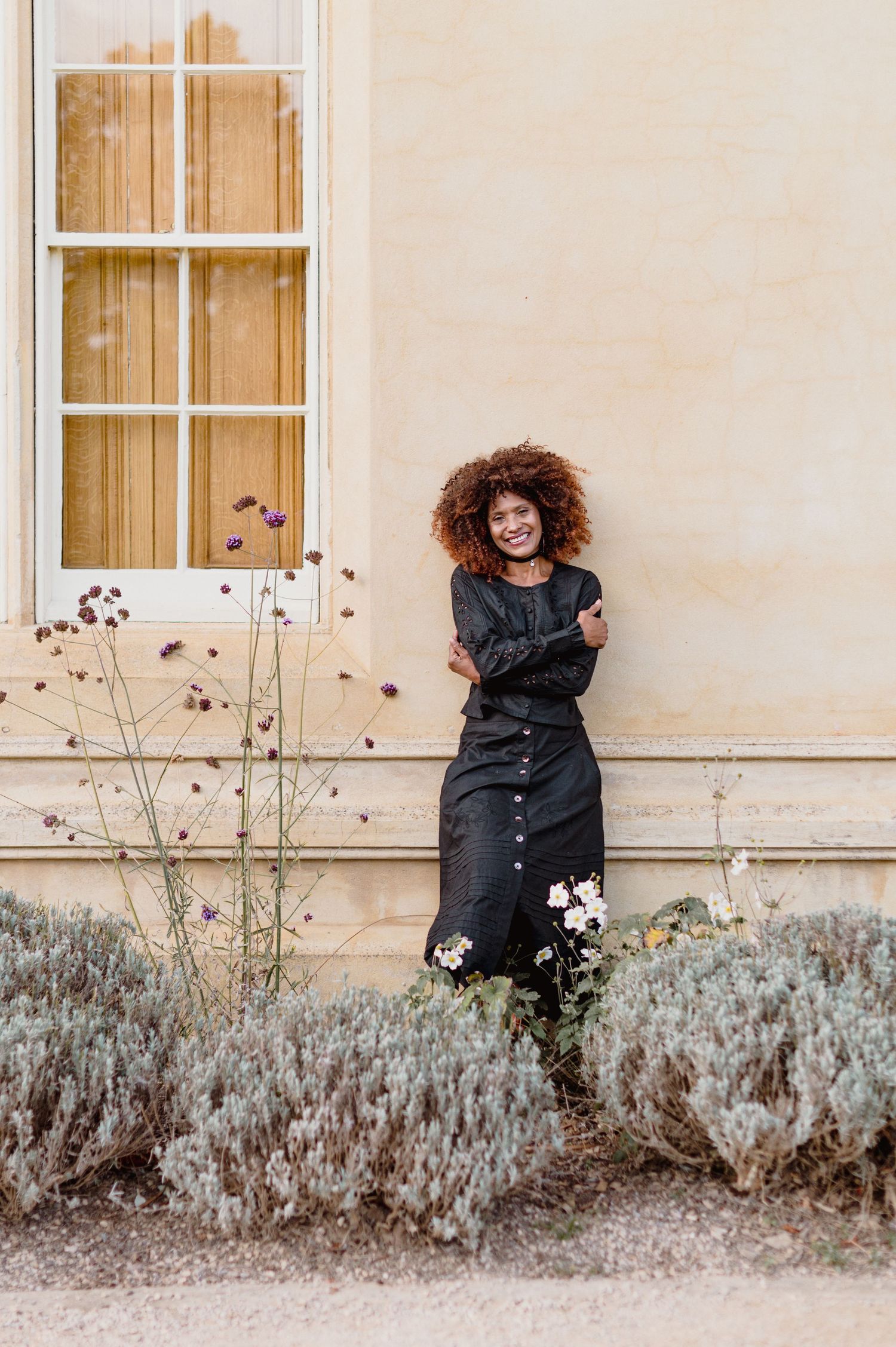 A playful sequence of photos showing a person peeking and hiding behind bushes against a beige wall with windows.