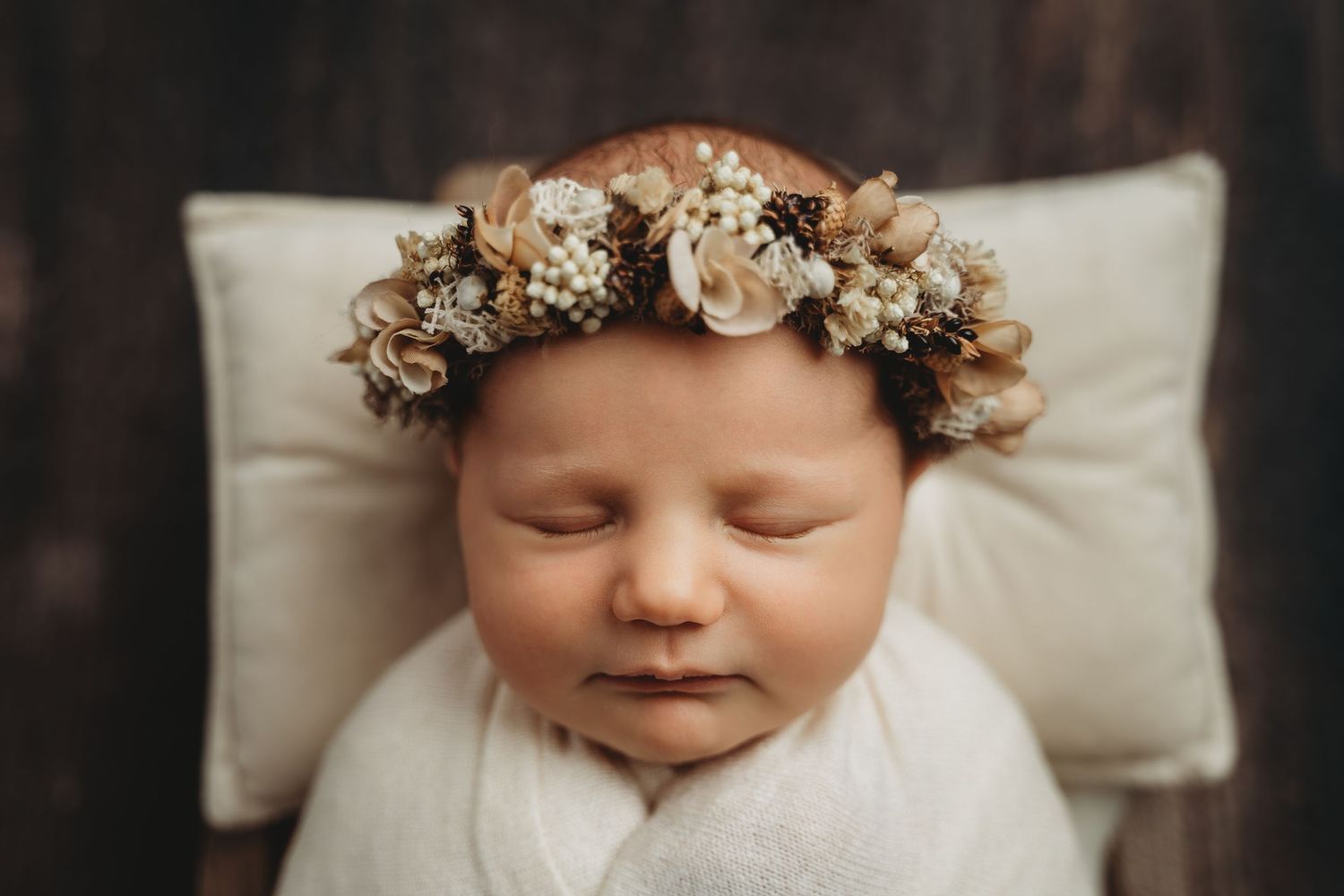 posed newborn photo, cream newborn photography, aerial newborn shot, newborn with flower headband, newborn photographer Nelson, photo studio