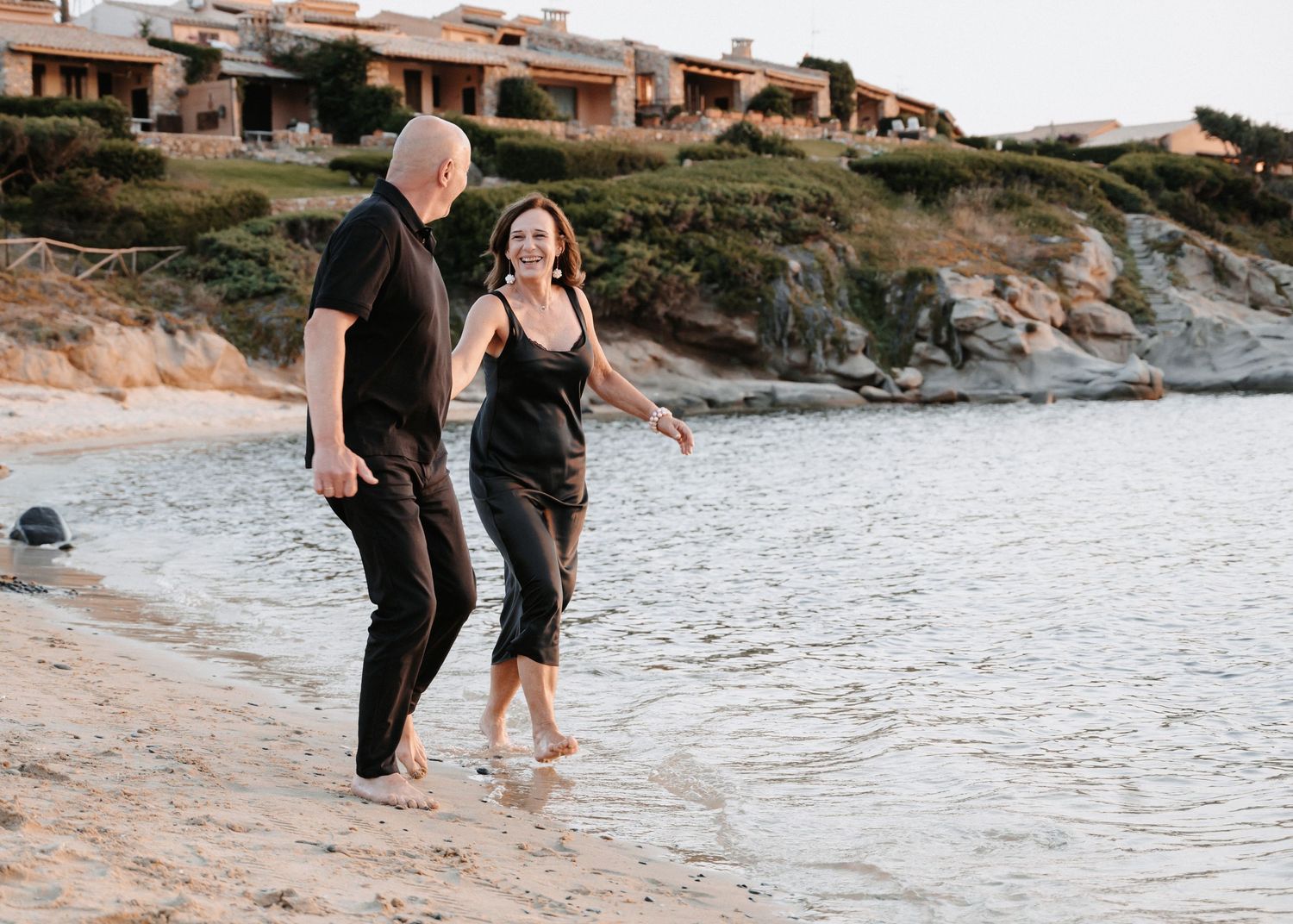 Paar läuft Hand in Hand am Strand von Sardinien entlang- romantische Küsten und Reisefotografie