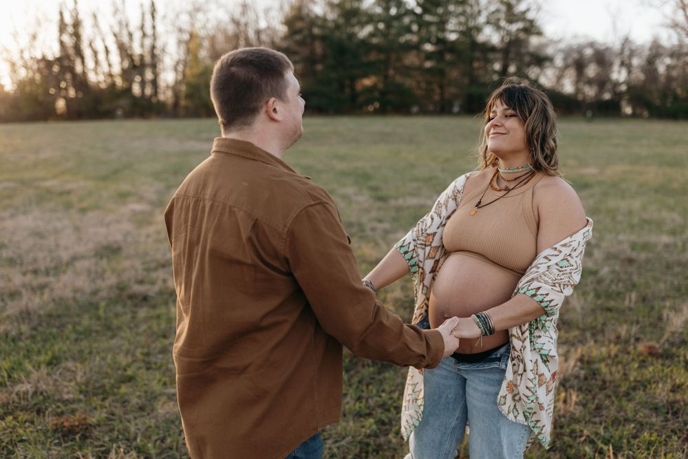 Couple shares intimate moment during sunset maternity photoshoot in field. Virginia/ North Carolina Maternity Session