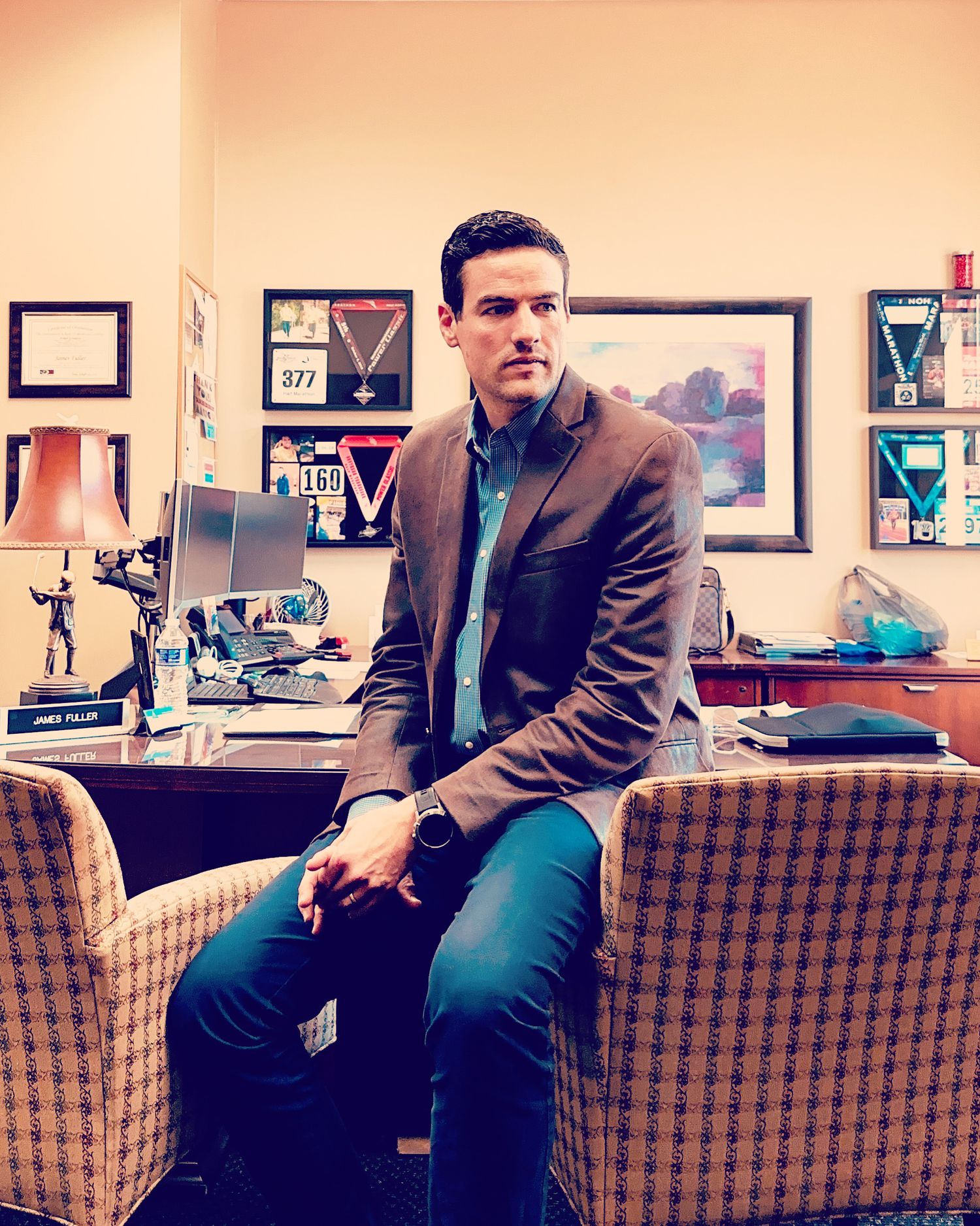 James Fuller leaning on the arm of an office chair