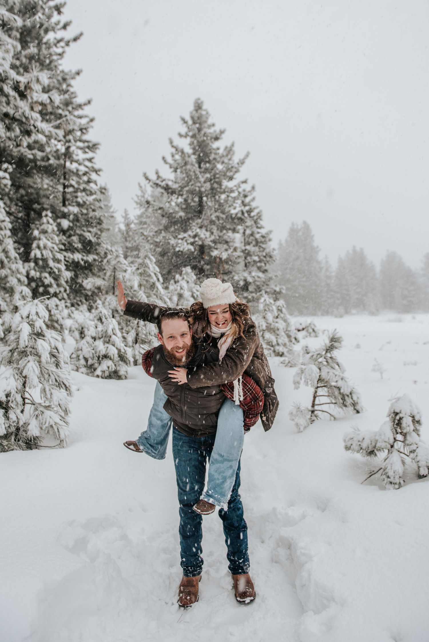 Couple enjoying a playful piggyback ride in a snowy Lake Tahoe forest – Winter couple photography by Alicia Alvey.