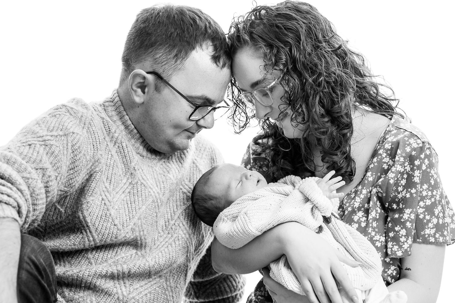parents with a baby on black and white