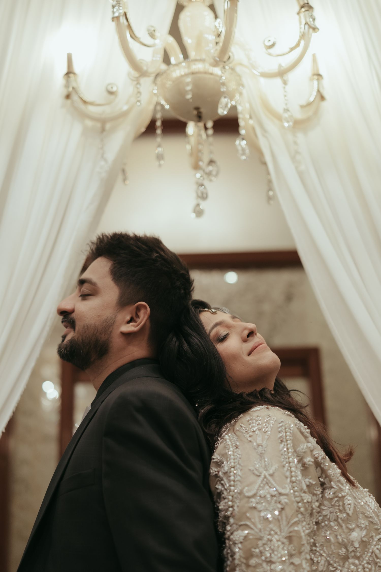 A romantic wedding portrait capturing an intimate moment between a couple in traditional South Asian attire.