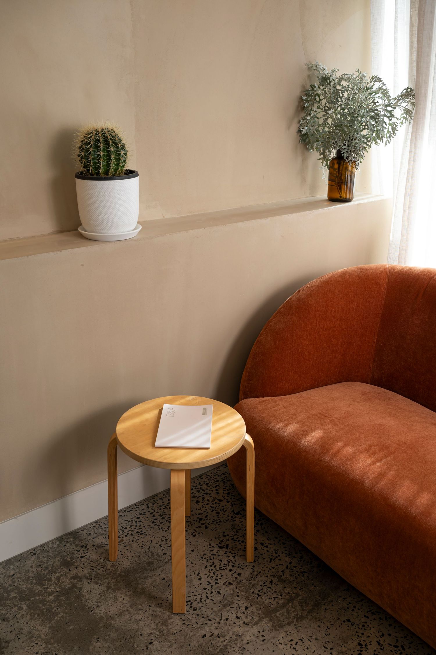 Boutique commercial interior photography featuring curved lounge seating, warm textures and natural window light