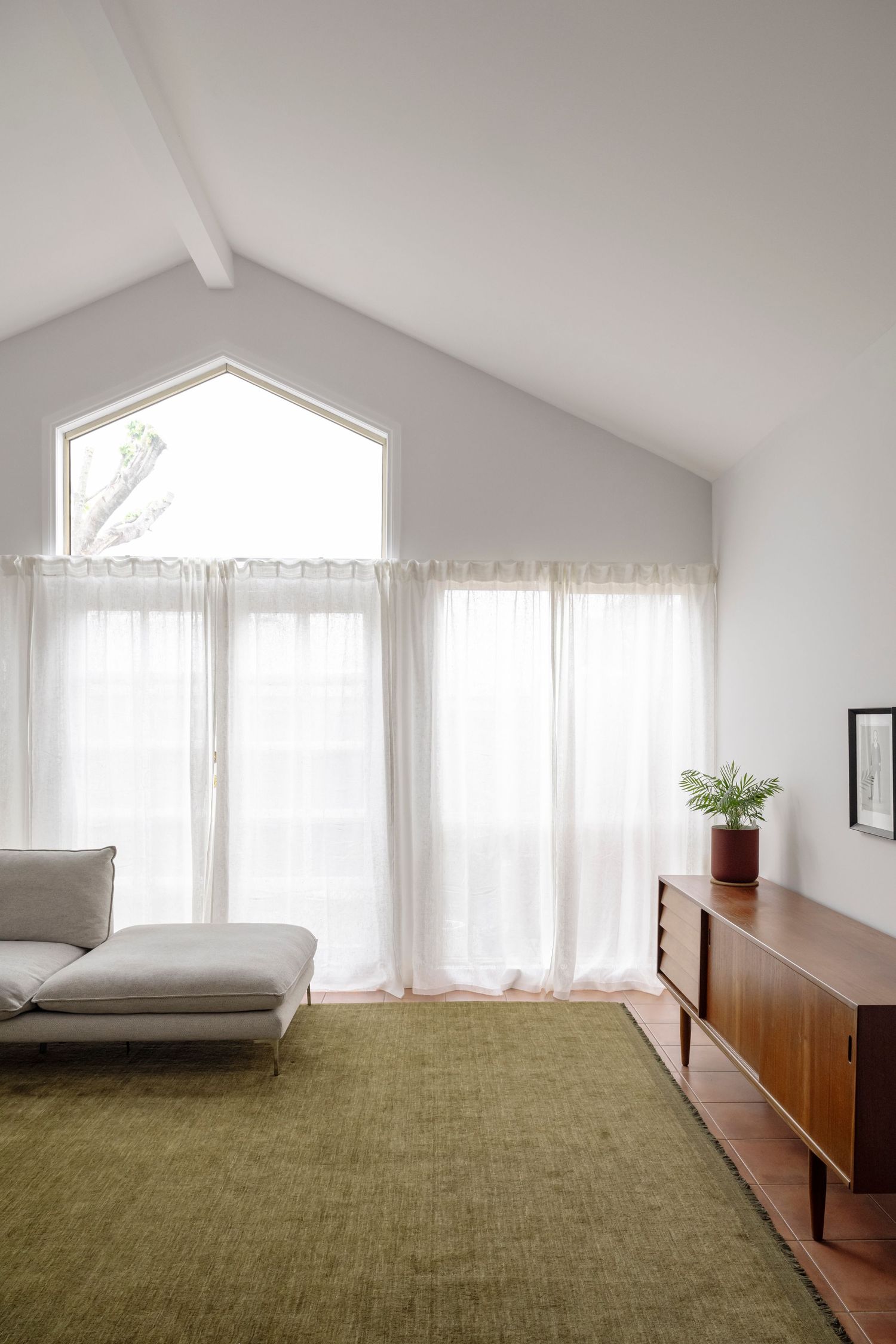Accommodation interior photography showcasing soft natural light and contemporary lounge design with vaulted ceilings