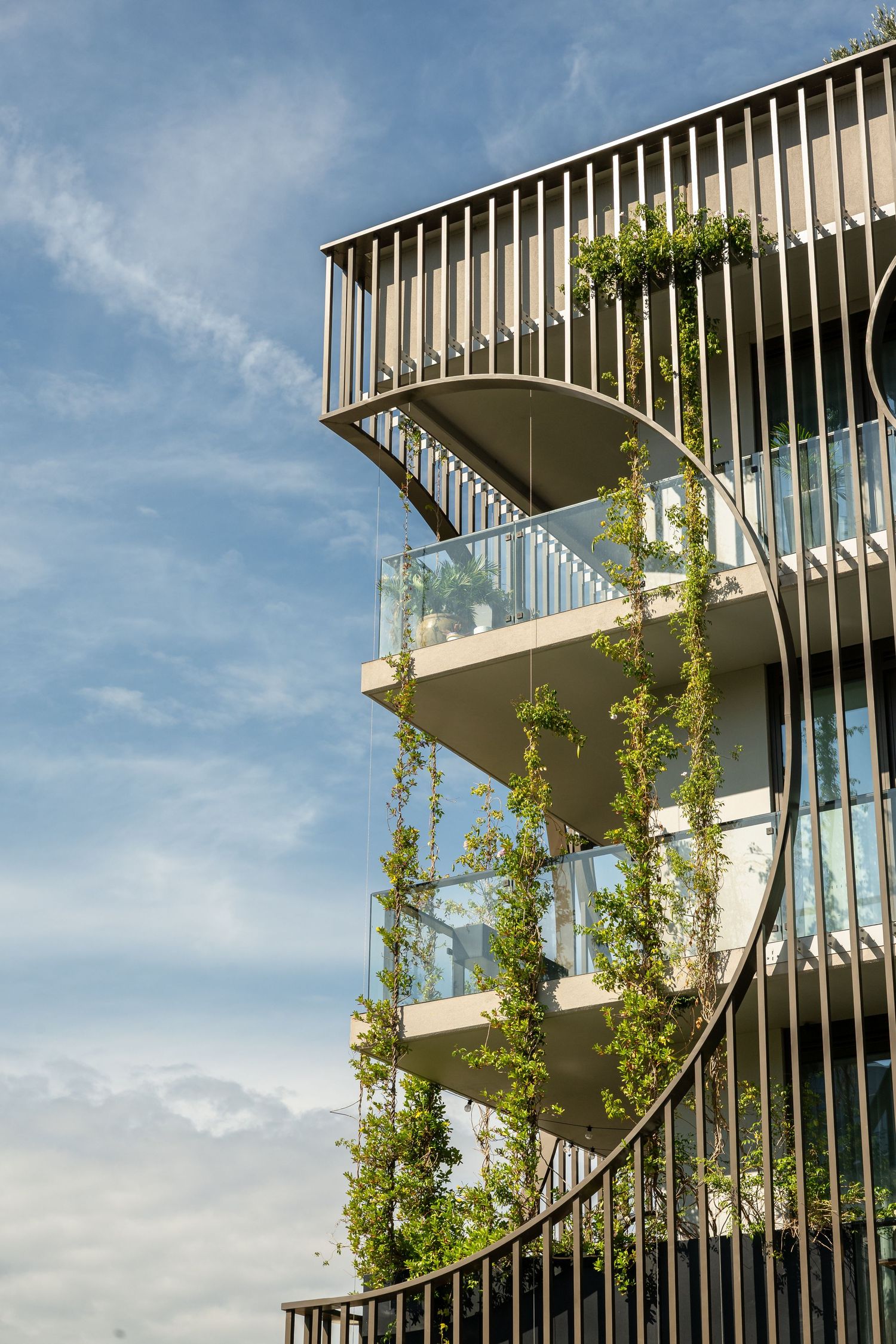 Contemporary apartment architecture photography showcasing curved balconies, vertical greenery and modern exterior design