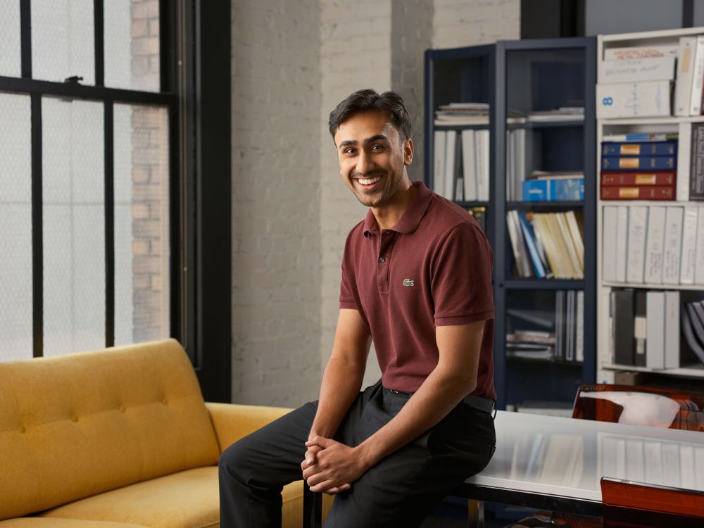 Professional portrait of a man seated in a modern office lounge with yellow sofa — corporate photography by Khoi Ly in Oakland.