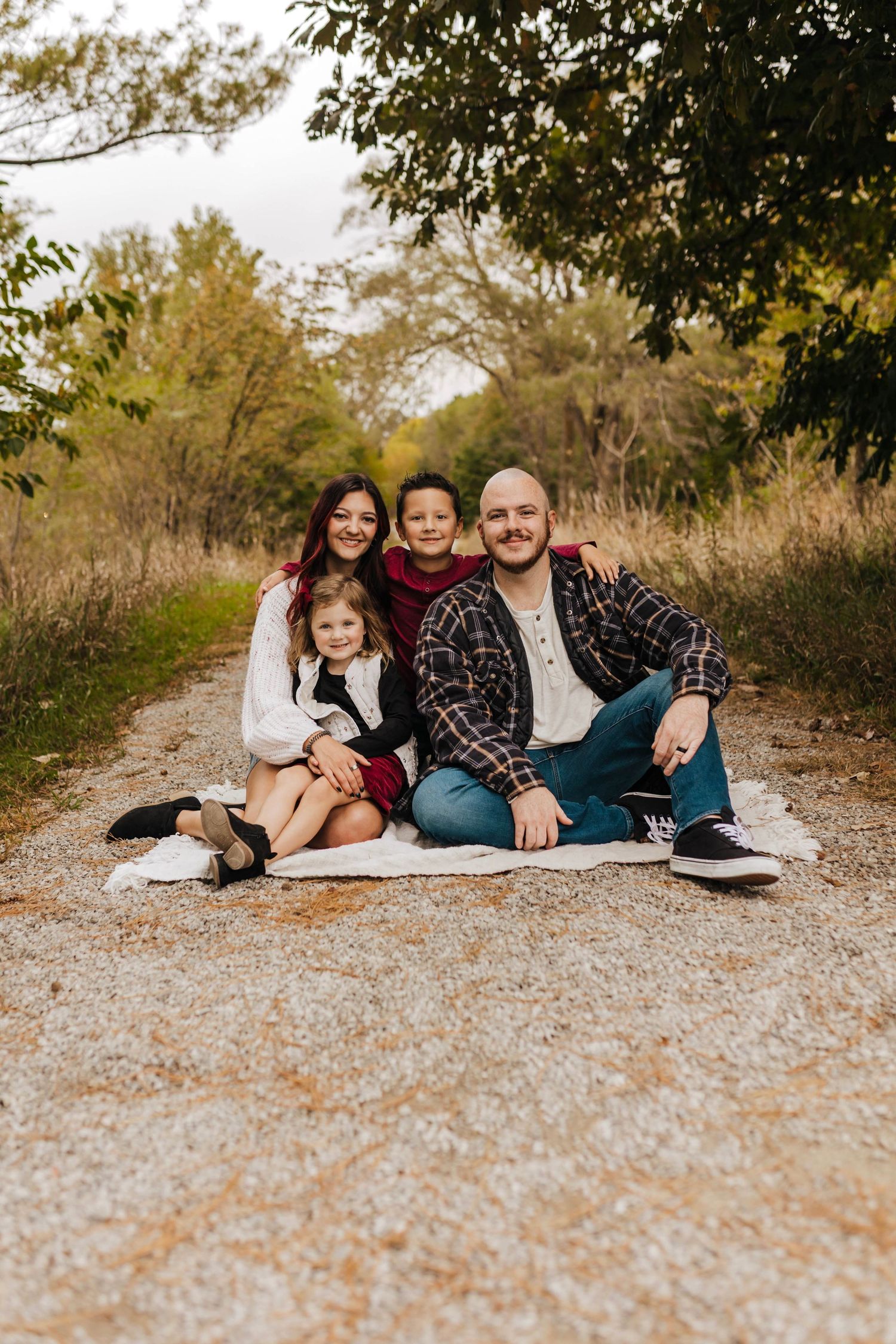 A family group poses together on a rocky overlook with mountain views at sunset.