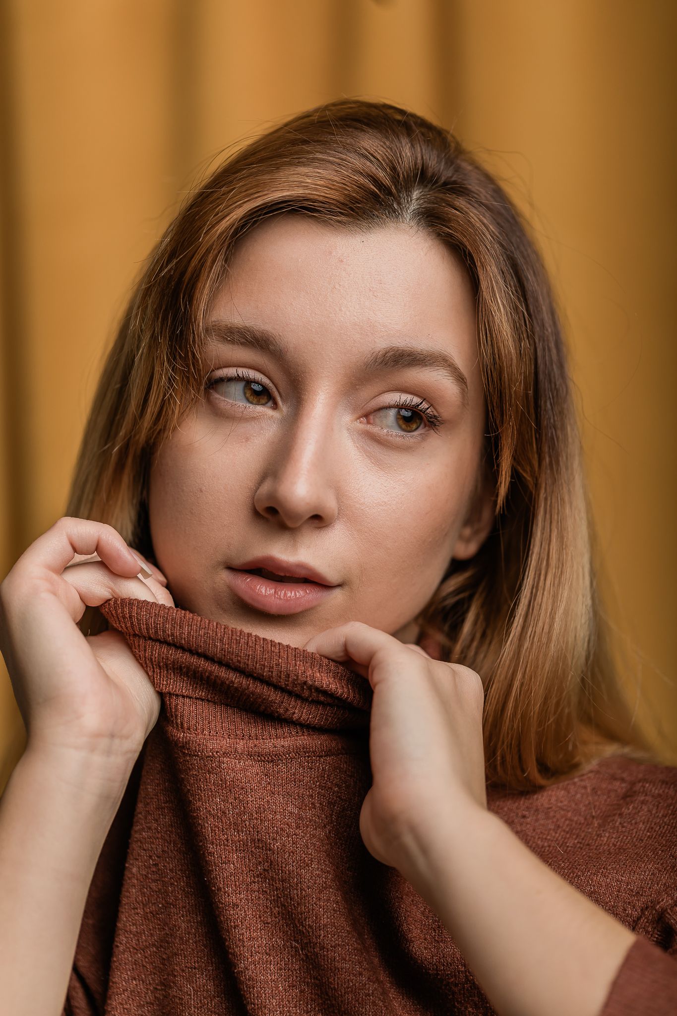Beautiful portrait with brown turtleneck sweater and soft brown backdrop creates warm, cozy autumn mood.