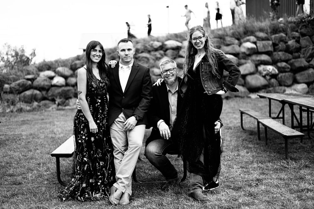 Natural engagement photo session with couple sitting and laughing on outdoor benches.