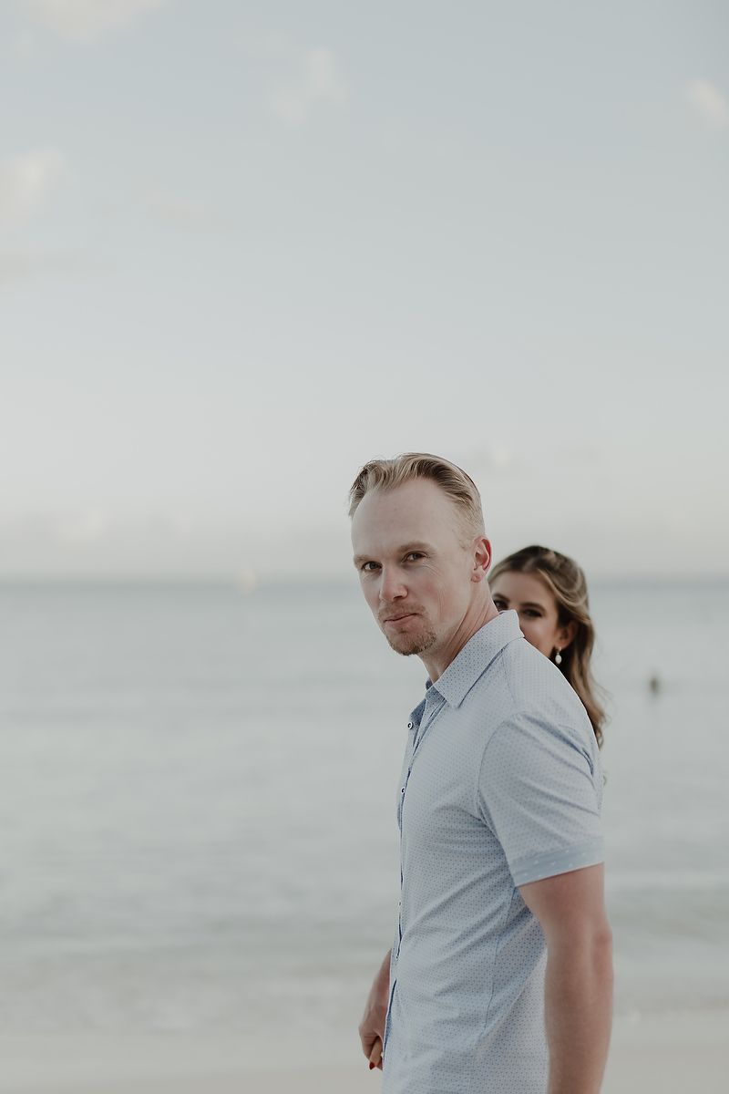 Engagement portrait of groom looking at the ocean during Playa del Carmen destination photoshoot.
