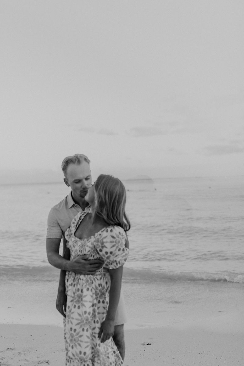 Black and white engagement portrait of couple embracing on the beach in the Riviera Maya.
