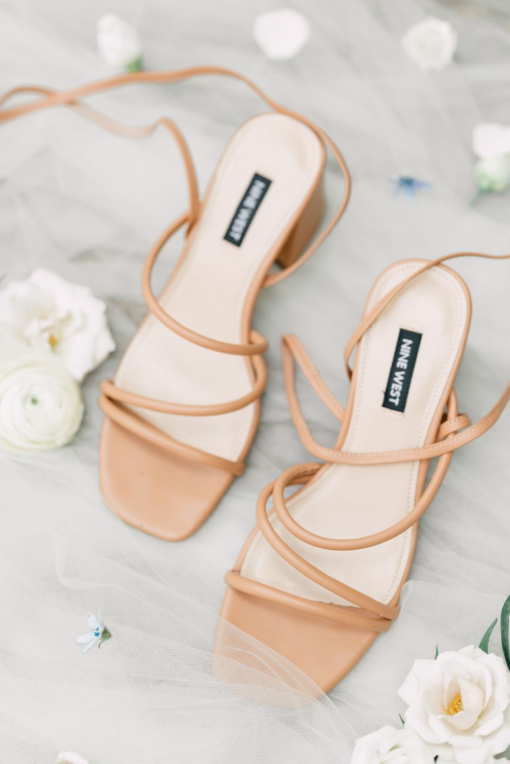 Elegant nude strappy sandals with white roses and delicate floral accents.