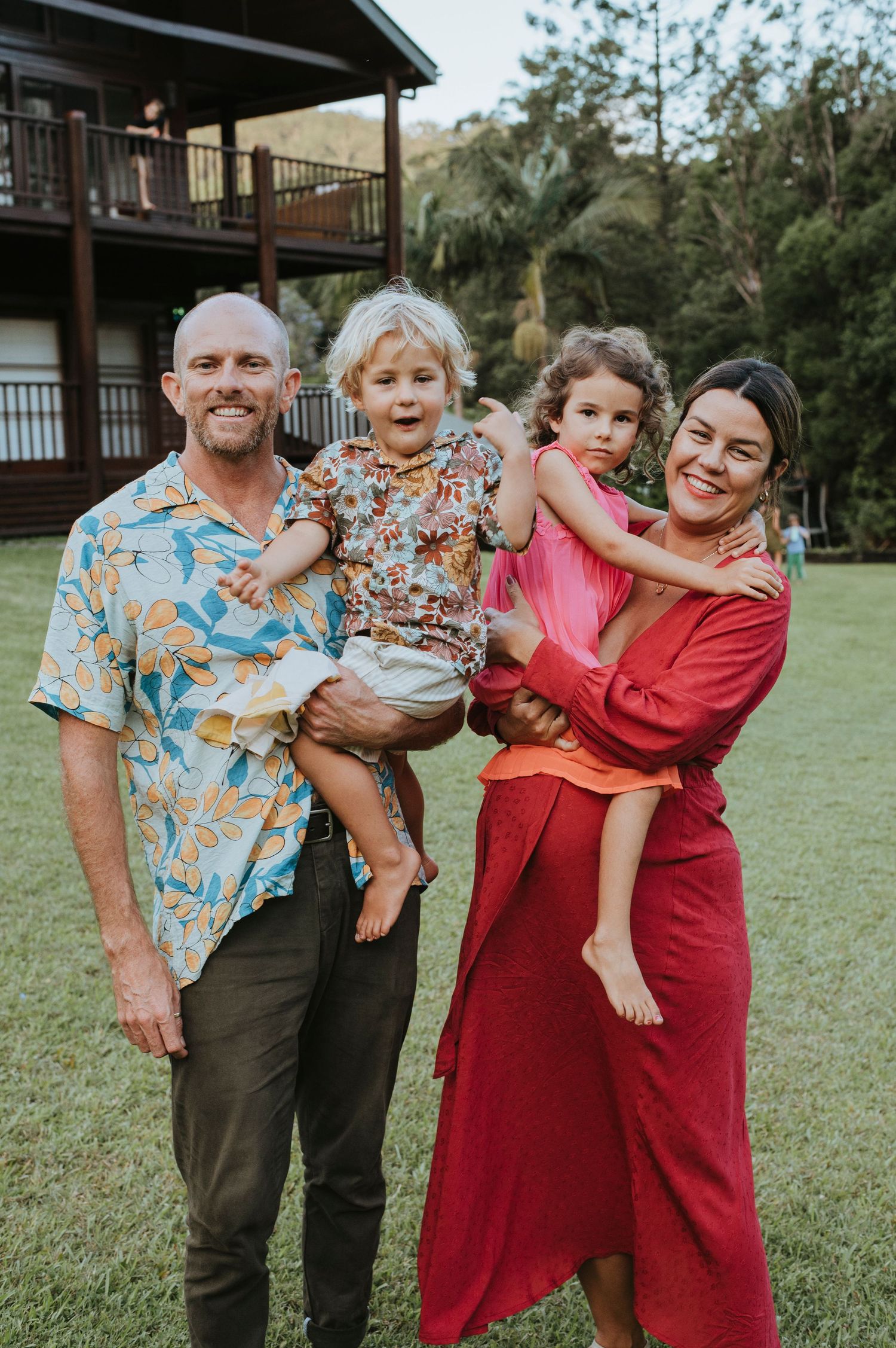 Family group photo with colorful casual attire standing together on green lawn.