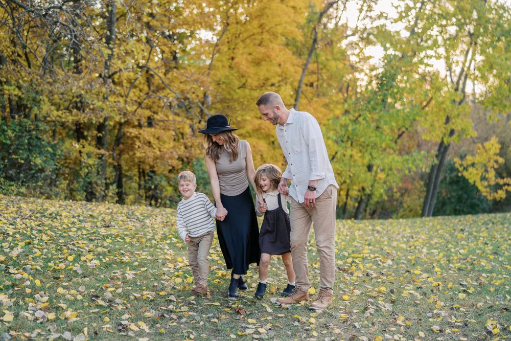 People enjoying time together in a field with golden fall foliage.