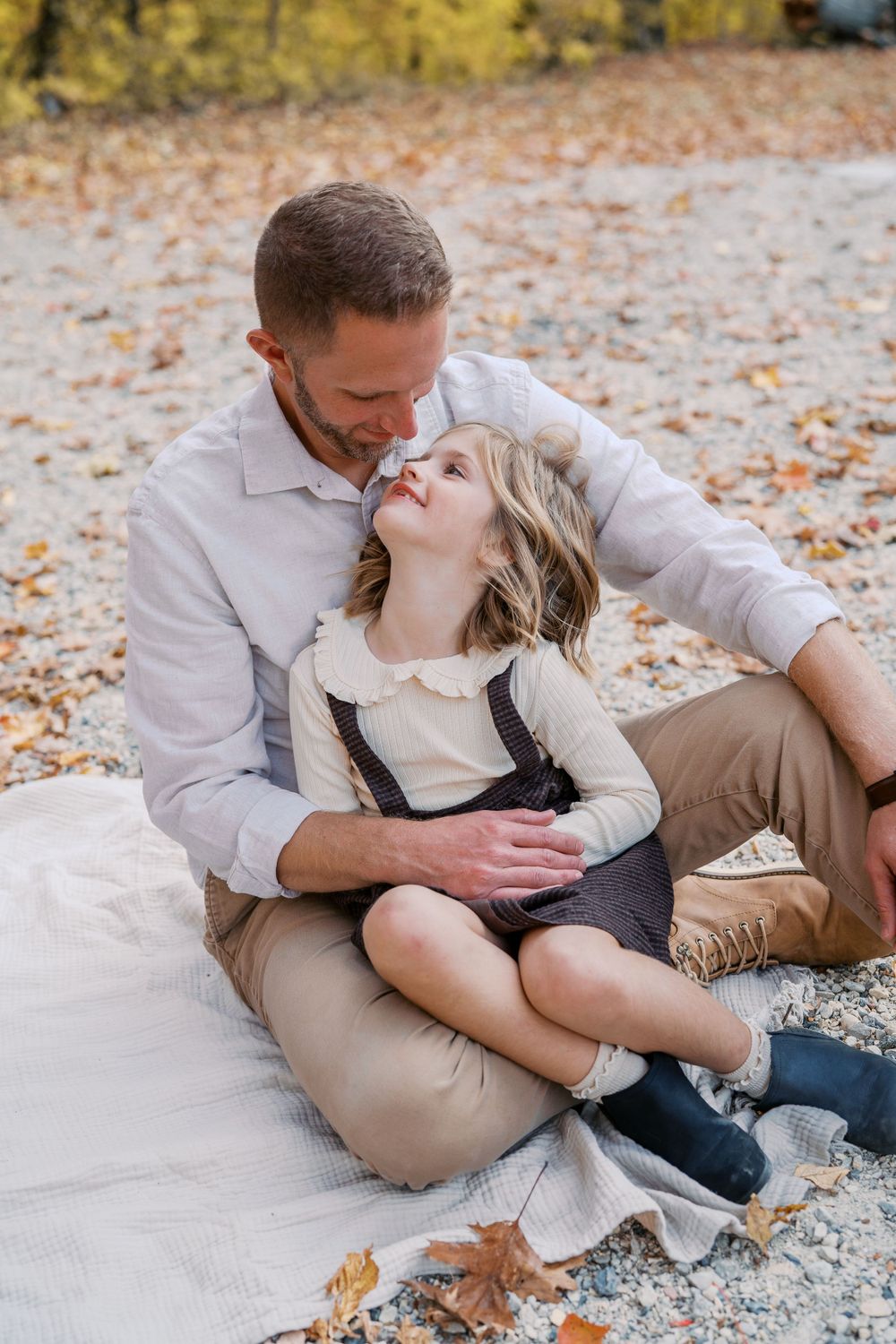 Candid family moments captured on blanket during fall photo session.