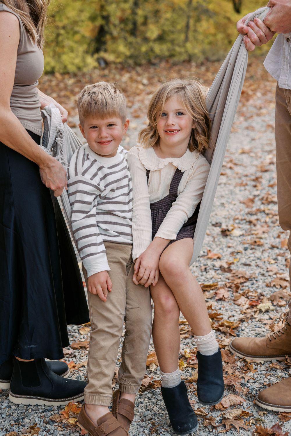 Close-up of family members' feet and legs during autumn photoshoot.