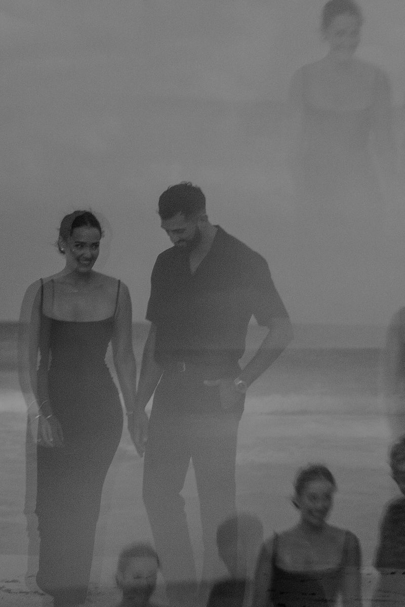 Couple walking hand in hand along the Caribbean shore during a Riviera Maya engagement photoshoot.
