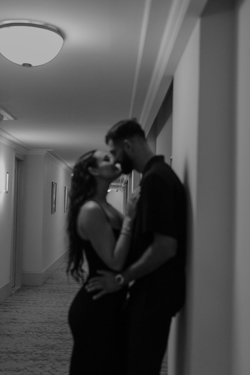 Romantic black-and-white portrait of a kiss inside Kempinski Hotel Cancún.