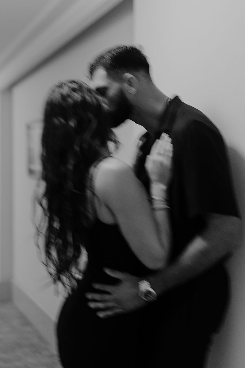 Editorial-style engagement portrait of a couple embracing in an elegant hotel hallway in Cancún.
