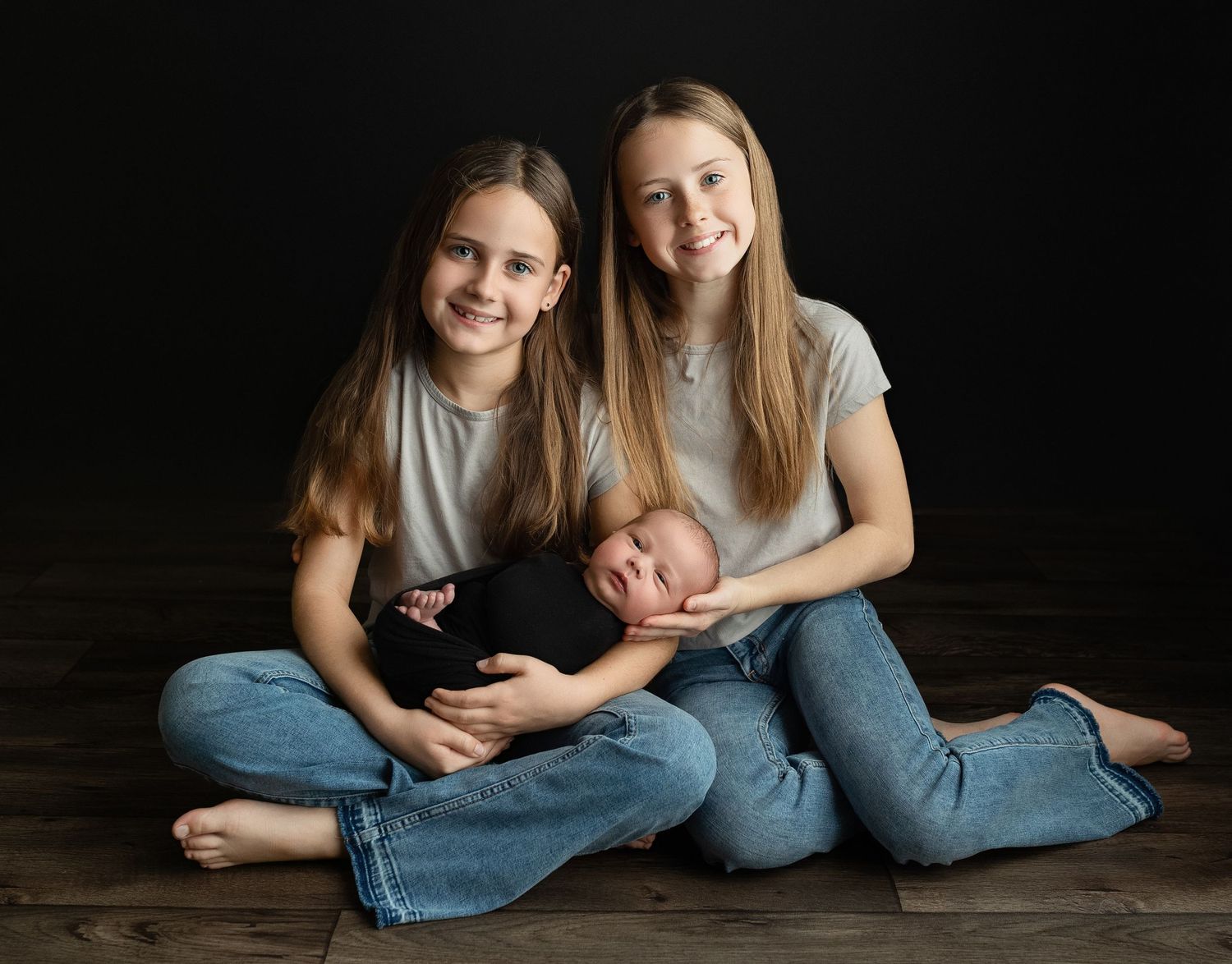 Big sisters are holding a newborn boy. Greenville SC newborn photographer, Easley, SC newborn photographer