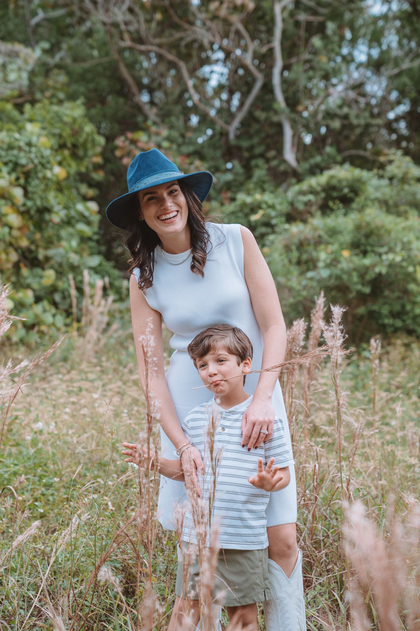 A parent and child share joyful moments together while playing in a wildflower meadow on a sunny day.