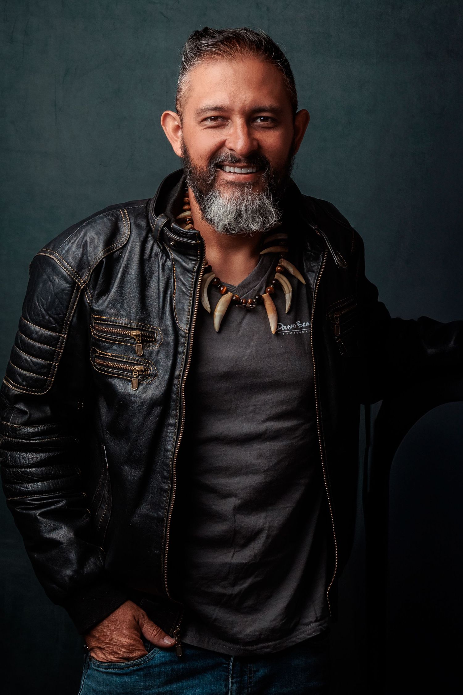 Portrait of a person in a leather jacket against a dark background.