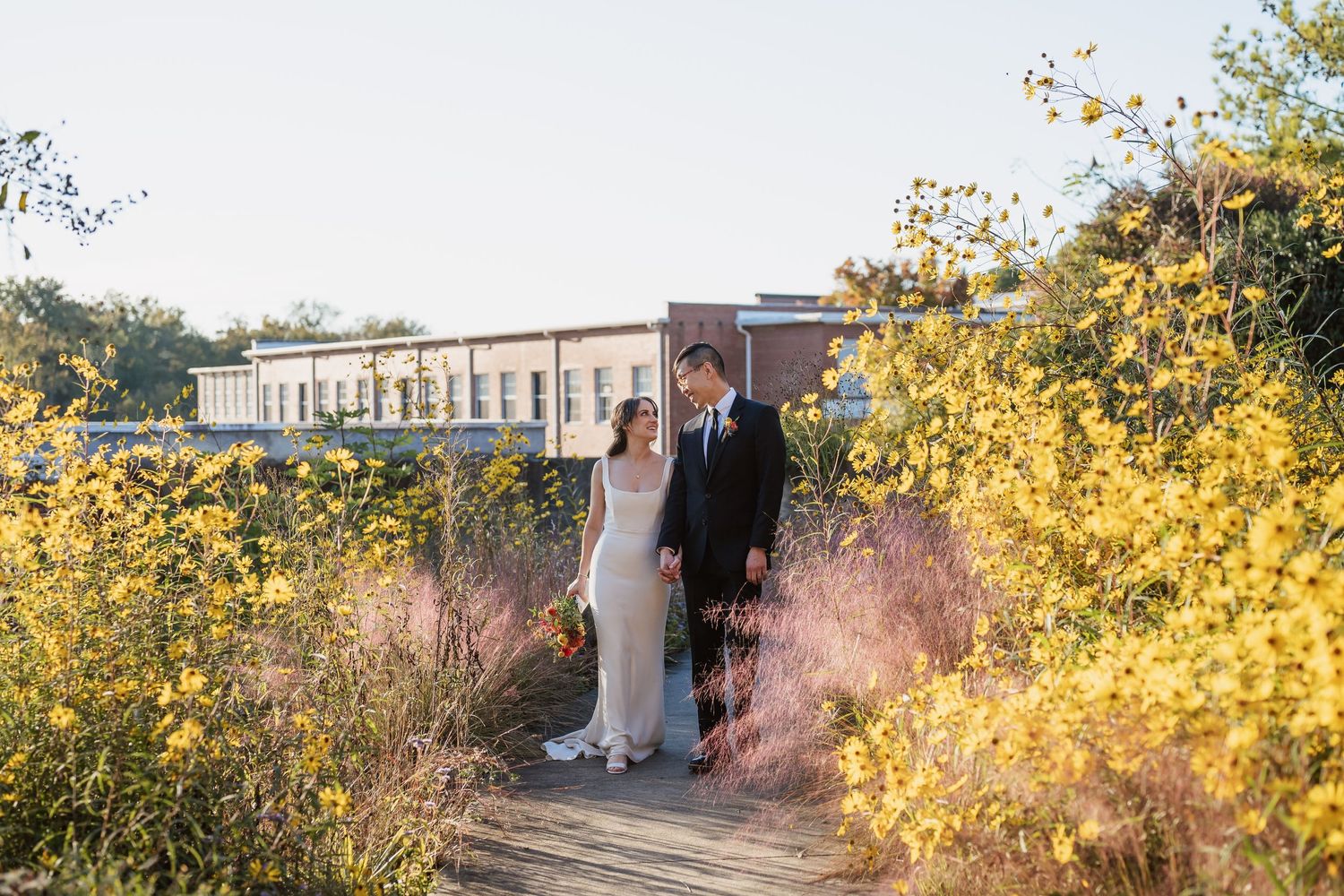 Couple holding hands on their wedding day at Haw River Ballroom in Saxapahaw North Carolina
