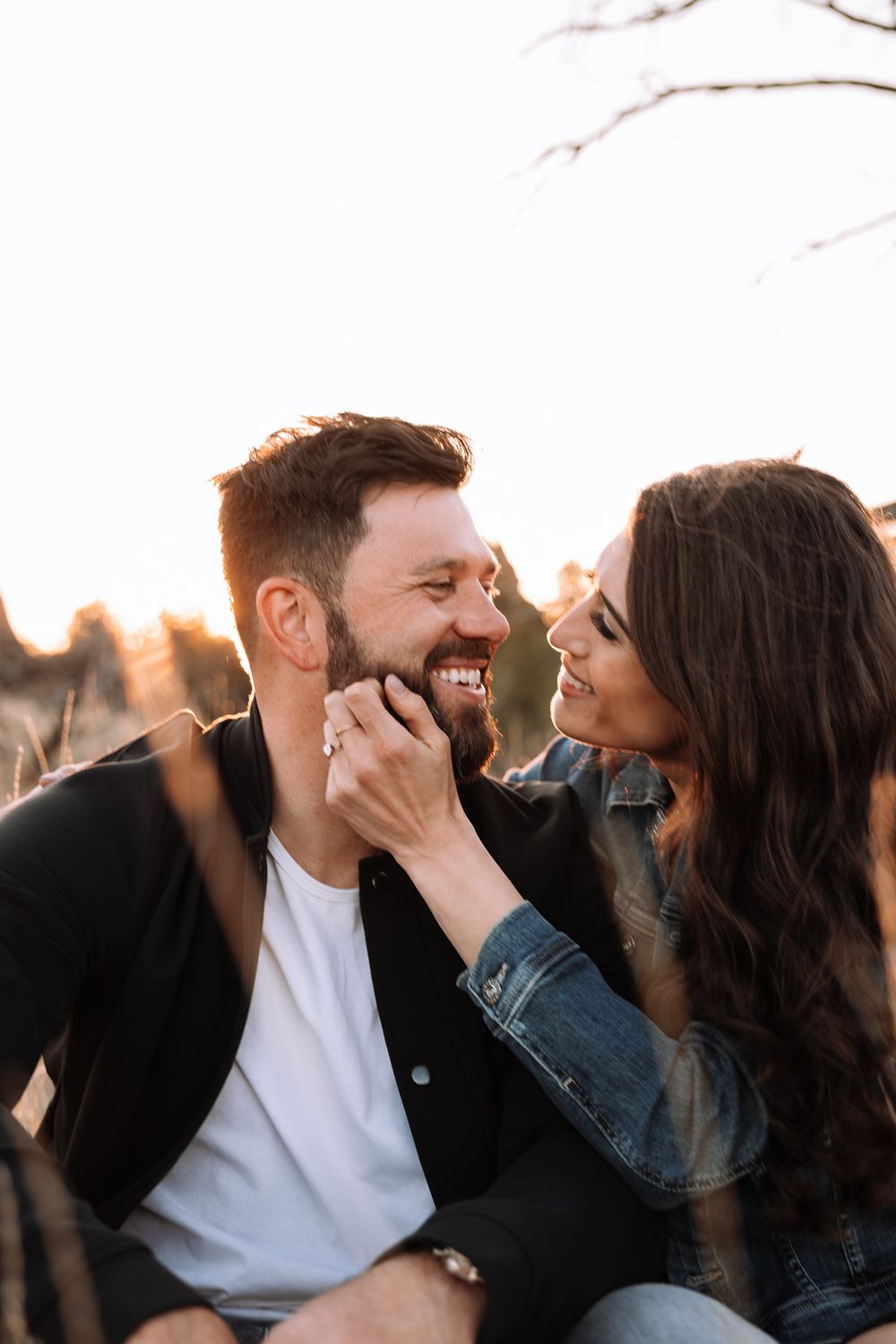 A joyful couple sharing an intimate moment outdoors during golden hour.