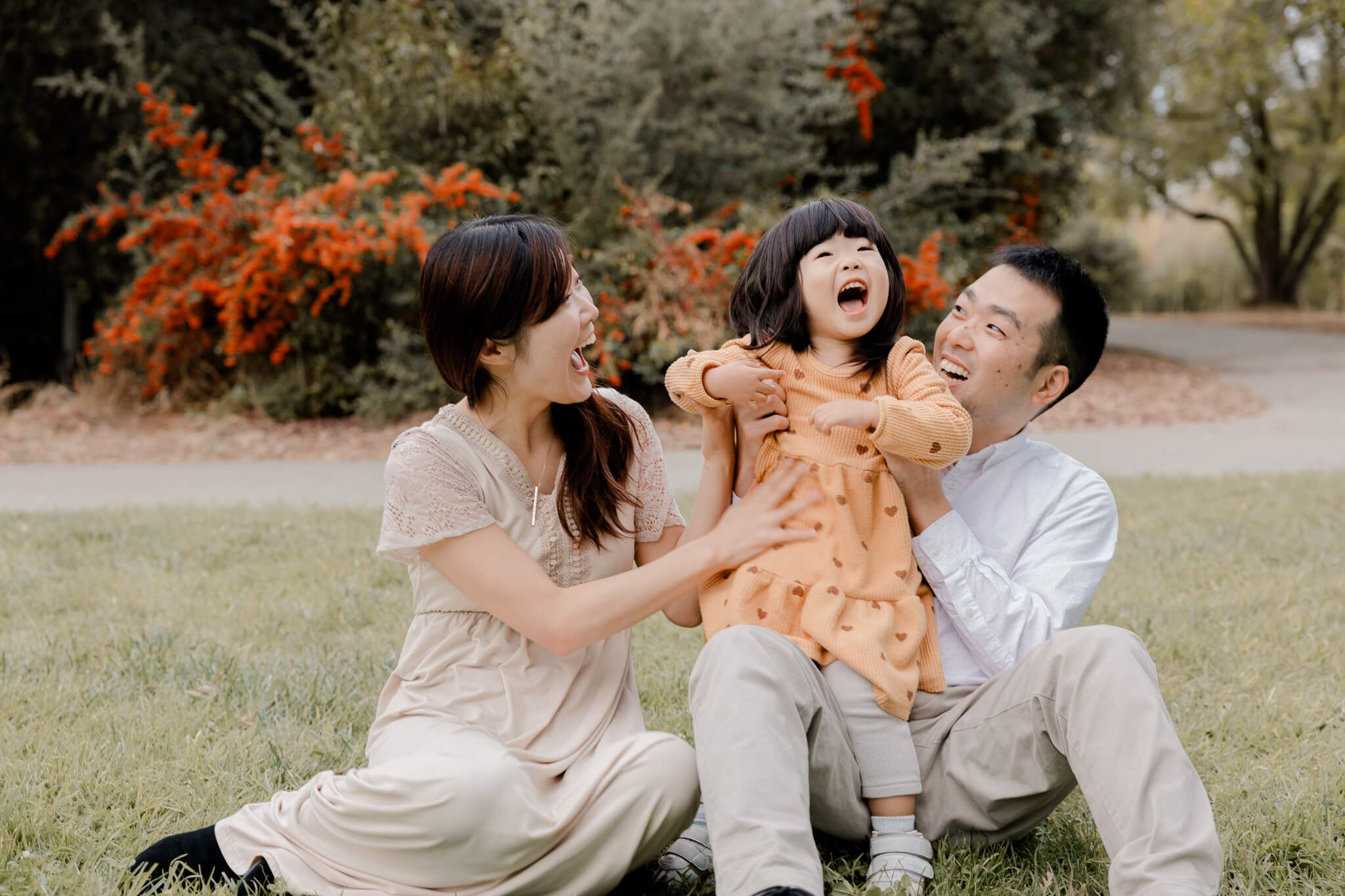 Candid family moment on grass with everyone laughing together outdoors, San Jose, CA
