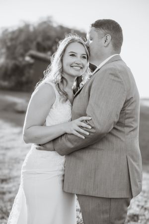 Romantic black and white portrait of a couple embracing on their wedding day.