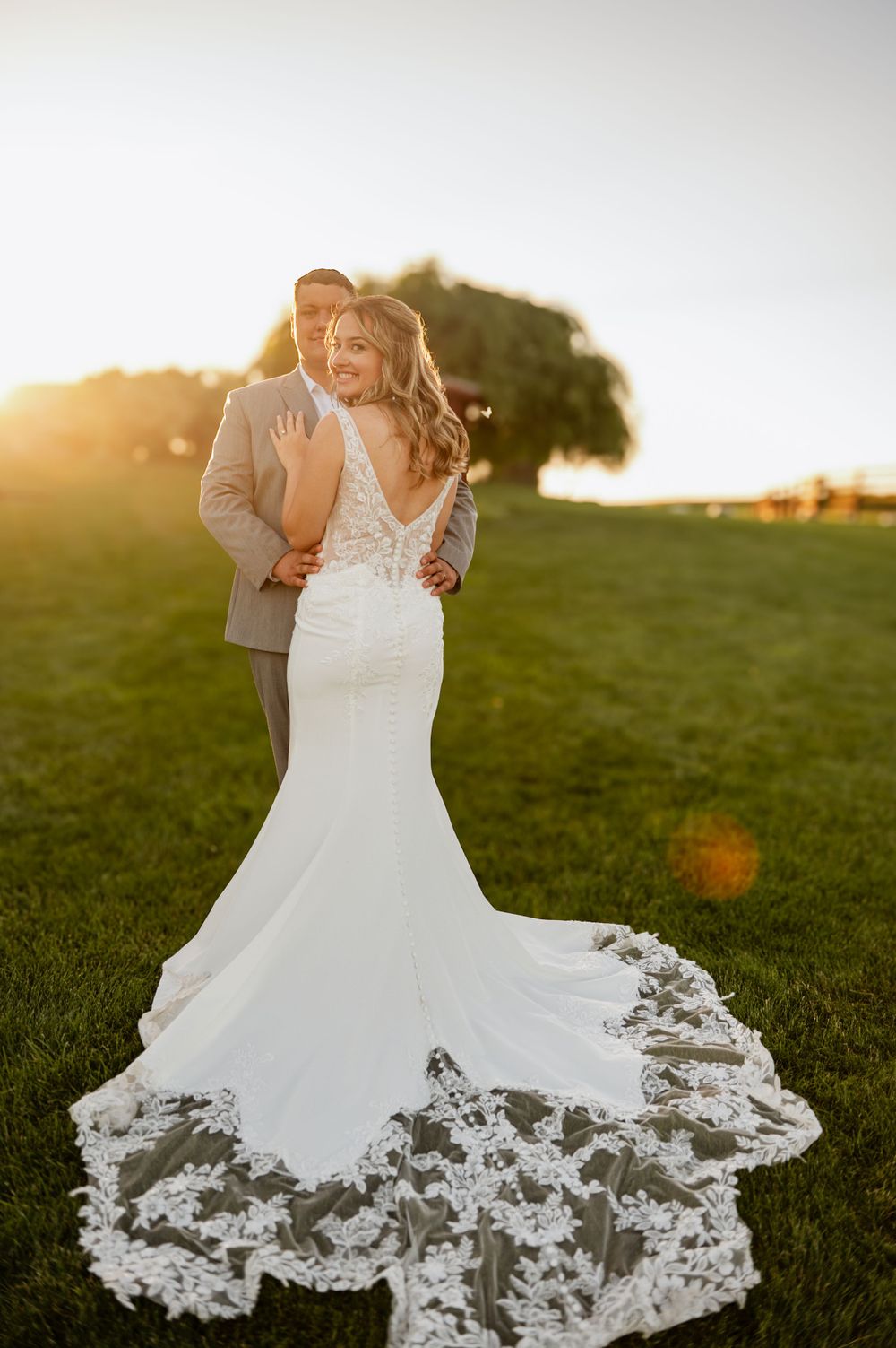 Stunning bridal portrait showcasing lace train of mermaid wedding gown at golden hour.