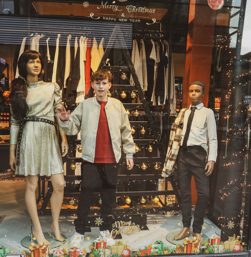 Vintage-style store window display with mannequins dressed in retro clothing.