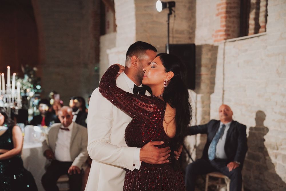 Couple shares romantic dance moment during reception in historic venue.
