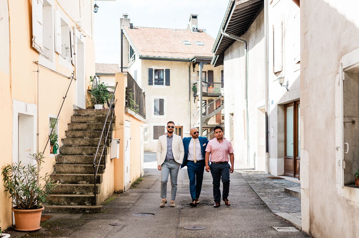 Groom and his two best friends walking just before meeting the bride on a street in Geneva, Switzerland before the civil wedding ceremony